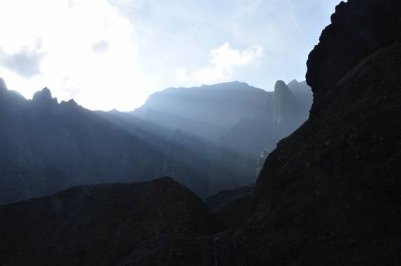 Luz do sol filtrada pelas nuvens e montanhas, na Kalalau Beach, na Na'Pali Coast, costa norte de Kauai, no Havaí